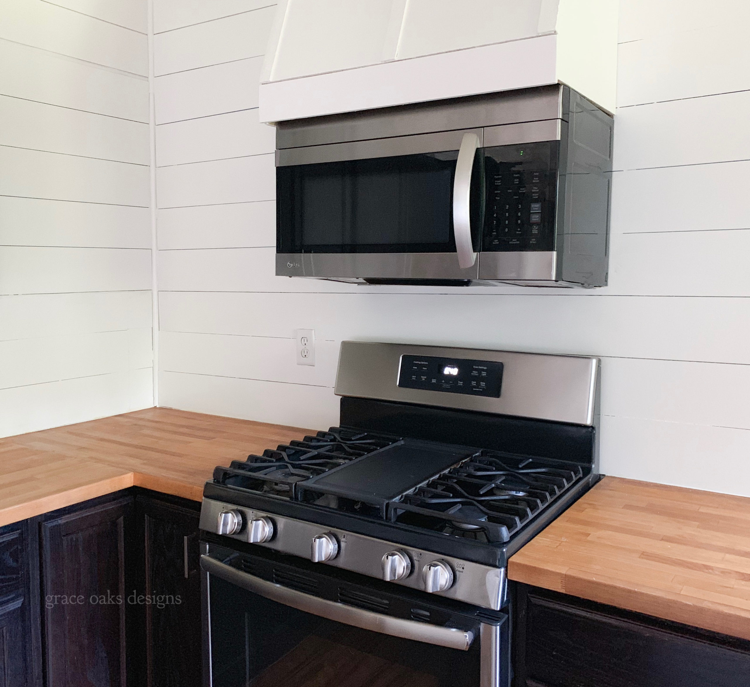 white shiplap kitchen with wood range hood